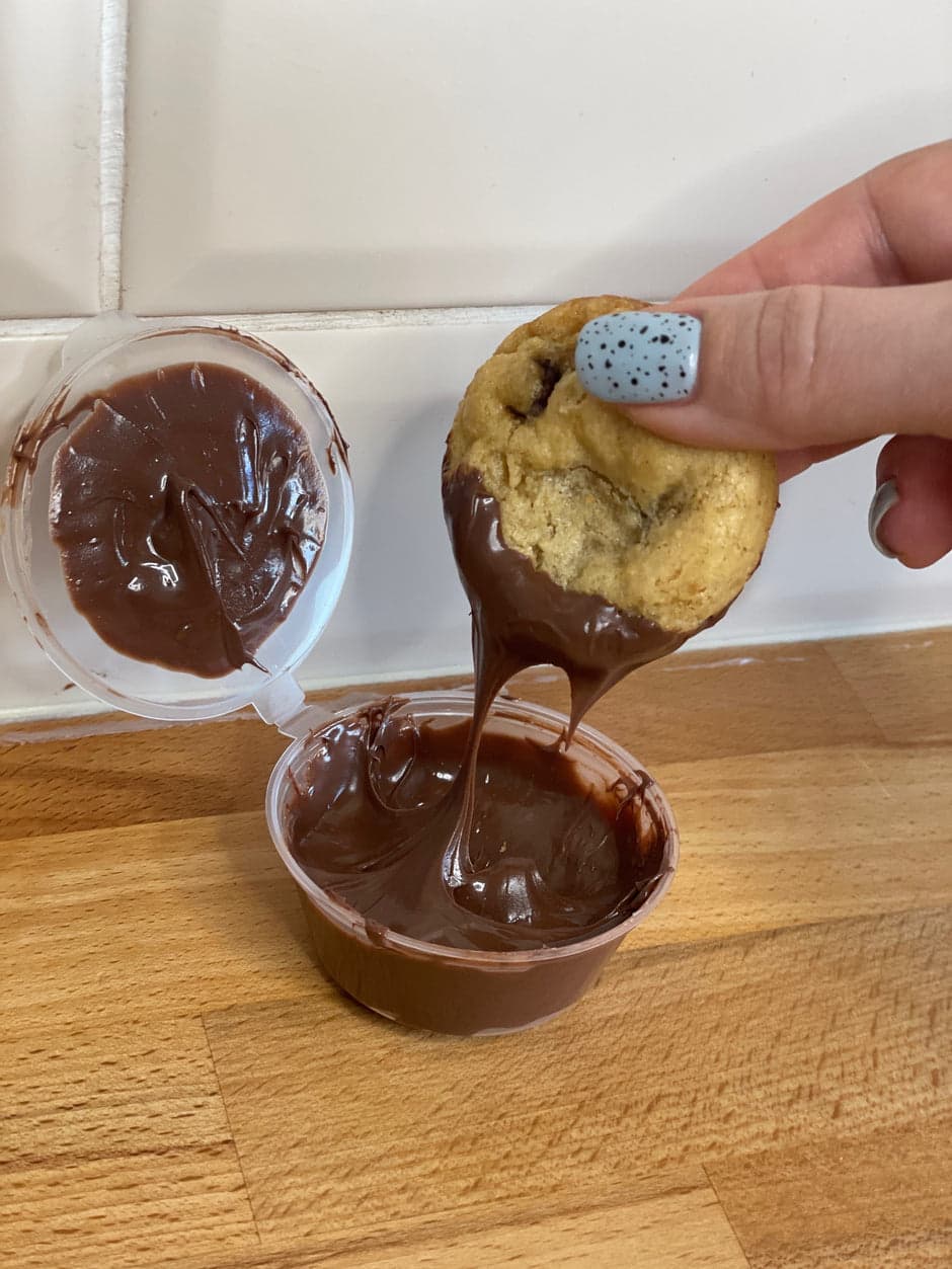 A cookie being dipped at home after delivery