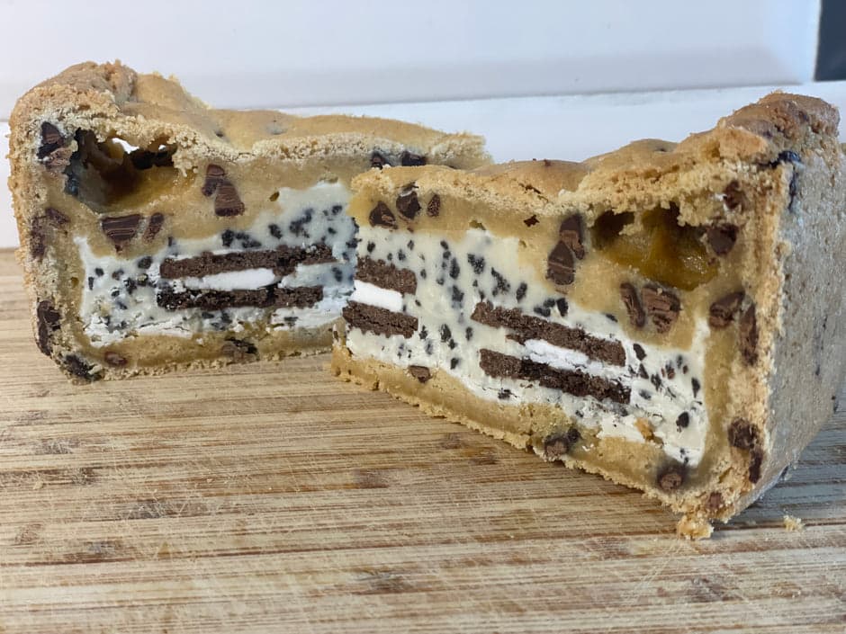 Triple chocolate cookie pie cross-section showing cream and cookie layers on a wooden board