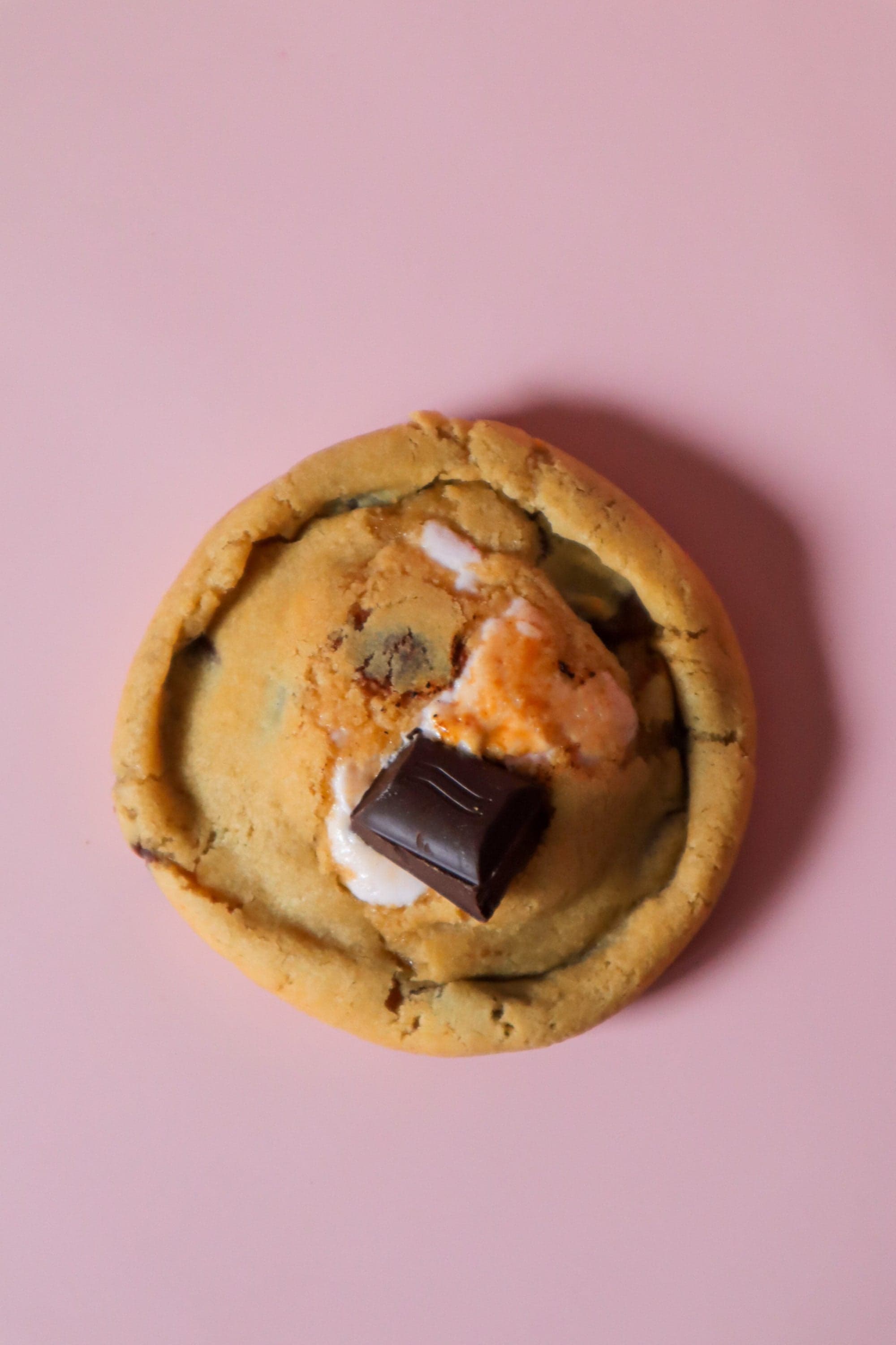 A top-down s’mores cookie with toasted marshmallow and a dark chocolate square